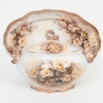 PORCELANA, uma (1) sopeira com tampa e presentoir, ornamentação pintada a mão em policromia pelo Atelier IOLANDA 1972, marca SCHMIDT (Pomerode, SC; Mauá, SP; Campo Largo, PR, fundada em 1945, ainda em atividade, maior fábrica de porcelana da América Latina), medindo a maior peça 38 x 24,5 cm, vide foto.