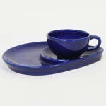 FAIANÇA, uma xícara de chá e pires com aba para biscoito, selo de marca da região de Nova Friburgo, RJ, tonalidade azul, medindo a maior peça 22 x 17 cm, ínfimos bicadinhos, sinais de uso, vide foto.