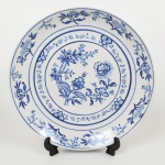 PORCELANA, um (1) medalhão decorativo, pintado a mão na técnica blue and white, representando flores, Assinado IOLANDA 1979, marca PORCELANARTE (empresa de decoração em porcelana de outras fábricas, funcionou nas décadas de 60/70 em Campo Largo, PR), medindo 32 cm diâmetro.