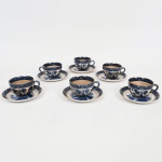 FAIANÇA JAPONESA, seis (6) xícaras para chá, ornamentação WILLON (Segundo a lenda chinesa: Um certo Mandarim tinha uma leal e devotada filha, possuidora de rara beleza. Certo dia, em que descobre que ela estava apaixonada por um carteiro que lhe fazia a corte, e que era por ela correspondida, expulsa a filha de casa e roga-lhe uma praga: que ao ser trocado o primeiro beijo pelo casal, eles se transformariam em dois pombos), também conhecida como pombinhos, tonalidade azul sobre fundo branco, arremates a ouro, possui manchas e o craquejado característico do envelhecimento de toda a faiança, marca N. K. T. - Imperial Ironstoneware, Made in Japan, uma xícara com rachado acentuado, sinais de uso, vide foto.
