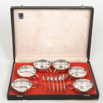 METAL PRATEADO, conjunto com doze (12) itens: 6 taças para sobremesa, pés esféricos, alças ornadas com guirlandas de tulipas; 6 colheres, ornadas em frisos e volutas, marcadas BELPRATA, acondicionado na caixa da BELLINI, sinais de uso, vide foto.