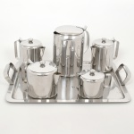 AÇO INOX, uma (1) baixela com seis (6) itens: 3 bules; 1 jarra; 1 açucareiro e 1 bandeja, somente a bandeja marcada EBERLE (Abramo Eberle 1880, Monte Magrè 1945, Caxias do Sul, veio com uma das primeiras levas de imigrantes italianos para o Brasil em 1884 junto com seus pais Giuzeppe Eberle e Luigia Zanrosso, seu pai abriu uma pequena funilaria mas como tinha que trabalhar na lavoura quem cuidava era a mãe e o pequeno Abramo ajudava na funilaria; em 1896 quando o pai resolveu vender a funilaria para concentrar os esforços da família na lavoura Abramo, com 16 anos de idade, se propôs a comprá-la do pai, em 1918 já com o nome Abramo Eberle & Cia iniciou a fabricação de talheres e utensílios de mesa, morreu em 1945 com 65 anos de idade e os filhos deram continuidade aos negócios até 1984 quando venderam para o Grupo Zivi), medindo a maior peça 42 x 32,5 cm, todos os itens com sinais de uso, vide foto.