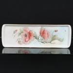 PORCELANA, uma (1) bandeja para rocambole, pintada a mão, representando flores em policromia, Atelier IEIE, arremates a ouro, sem marca de manufatura aparente, medindo 38 x 13 cm, vide foto.