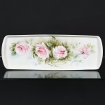 PORCELANA, uma (1) bandeja para rocambole, pintada a mão, representando rosas em policromia, Atelier IOLANDA 1979, sem marca de manufatura aparente, medindo 38,5 x 13,5 cm, vide foto.