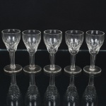 VIDRO, cinco (5) taças de pé alto para licor, incolores e translúcidas, bojo com parte inferior lapidada em treliças, fuste quase cilíndrico, base em bolacha, medindo 8,5 cm altura, sinais de uso, vide foto.