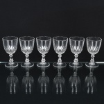 DEMI CRISTAL, seis (6) taças de pé alto para licor, incolores e translúcidas, bojo ligeiramente obcônico, terço inferior moldado em sulcos, fuste hexagonal na forma de coluneta, base em bolacha, medindo 9 cm altura, sinais de uso, vide foto.