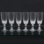 DEMI CRISTAL, seis (6) flutes de pé alto para champanhe ou espumante, incolores e translúcidas, bojo ligeiramente obcônico, terço inferior moldado em sulcos, fuste hexagonal na forma de coluneta, base em bolacha, medindo 16 cm altura, sinais de uso, vide foto.