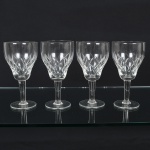 VIDRO, quatro (4) taças de pé alto para vinho branco, incolores e translúcidas, bojo com parte inferior lapidada em treliças, fuste quase cilíndrico, base em bolacha, medindo 15,5 cm altura, sinais de uso, vide foto.