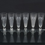 VIDRO, seis (6) flutes , incolores e translúcidos, para cerveja ou espumante, base em bolacha, bojo lapidado em sulcos e dedão, medindo 20 cm altura.