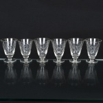 VIDRO, seis (6) taças de pé alto para licor, incolores e translúcidas, bojo com parte inferior lapidada em treliças, fuste quase cilíndrico, base em bolacha, medindo 8 cm altura, sinais de uso, vide foto.