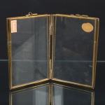 FOTOGRAFIA, um (1) porta-retratos dupla face, confeccionado com placas em vidro, monture em metal, medindo fechado 13 x 9 cm, sinais de uso, vide foto.
