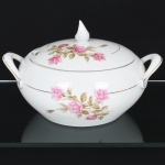 PORCELANA, uma (1) sopeira com tampa, ornada com rosas em policromia, arremates com frisos a ouro, marca SCHMIDT (Pomerode, SC; Mauá, SP; Campo Largo, PR, fundada em 1945, ainda em atividade, maior fábrica de porcelana da América Latina), medindo 23,5 cm diâmetro mais as alças, vide foto.