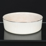 PORCELANA REFRATÁRIA, uma (1) travessa circular de borda alta e canelada, arremates com frisos prateados, marca CONDESSA (Blumenau, SC, 1956 a 1967, fundada por Nicolas Coman e Hercílio Deeke), possui craquejados, medindo 24,5 cm diâmetro e 7,5 cm altura, sinais de uso, vide foto.