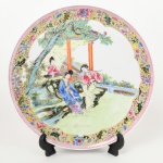 Exepcional prato de coleção em porcelana chinesa, rica decoração em esmalte policromado, representando gueixas em cena do cotidiano, borda circundada por barrado geométrico. Marcado com ideograma no verso. Med.: Diam. 27,5 cm.