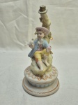 Linda escultura, castiçal de menino com pássaro em porcelana com policromia. Medindo 22,5cm de altura. Com uma perda na mão.