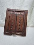 Placa decorativa vintage em madeira entalhada representando as Tábuas da Lei com inscrições em caracteres hebraicos e acabamento rústico. Medindo 35,5cm x 29,5cm.