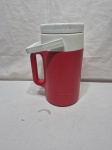 Garrafa térmica para camping da marca Thermos em plastico duro. Medindo 13cm x 27cm de altura.