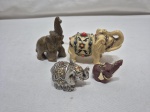 Lote de 4 enfeites na forma de elefante, sendo em pedra e resina. Medindo o maior 9cm de altura.