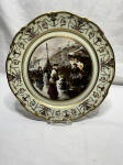Lindo prato decorativo em porcelana com cena galante decorada com guirlanda floral e friso ouro. Medindo 32,5cm de diâmetro.