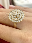 ANEL MONUMENTAL EM OURO 18K COM PAVÊ DE DIAMANTES. Anel em ouro amarelo 18k, de concepção marcadamente volumosa, apresentando topo circular amplo integralmente recoberto por pavê de diamantes, com peso estimado total de aproximadamente 3,55 ct. Os diamantes, de lapidação brilhante, encontram-se dispostos em múltiplas fileiras concêntricas, criando superfície contínua de alto brilho e forte impacto luminoso. A cravação em microgarras confere unidade visual ao conjunto, formando um verdadeiro tapete de luz. Estrutura robusta, com galeria vazada em formato radial  solução clássica que permite leveza visual ao volume e melhor entrada de luz sob as pedras. Aro duplo/estriado, reforçado, adequado à proporção do tampo, garantindo equilíbrio e conforto no uso. Peça de linguagem contemporânea, com forte influência da joalheria de impacto das últimas décadas do século XX, concebida para protagonismo absoluto em uso.Aro: 24. Peso: 8,88 g. Material: ouro 18k. Pedras: diamantes em pavê ( 3,55 ct total).