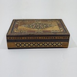 Caixa Porta Jóias em Madeira Marchetada,  Veludo na Parte de Dentro, Com Detalhes pelo Uso. Medidas: Altura: 4 cm, Largura: 10 cm, Comprimento: 14,5 cm, Peso: 180 g.