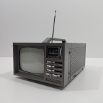 Antiga Mini TV 5 Polegadas Portátil, Com Rádio AM/FM, Marca deluxe, Modelo CTRE 864, Faltando um Botão na Parte de Cima, Não Acompanha o Fio, Não testao o Funcionamento. Medidas: Altura: 12 cm, Largura: 20 cm, Comprimento: 26 cm, Peso: 2040 g.