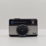 Câmera Fotográfica Analógica, Marca Kodak, Modelo INSTAMATIC  155X, Com Detalhes pelo Uso, Não testado o funcionamento. Medidas: Altura: 6,5 cm, Largura: 3,5 cm, Comprimento: 11 cm, Peso: 190 g.