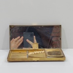 Antiga Cigarreira e Porta Maquiagem, Década de 40, Em Metal Dourado, Sem marca aparente, Com Desgastes pelo Tempo e Uso, Com o Fecho Quebrado, Na Caixa, necessíta restauro. Medidas da Caixa: Altura: 2,5 cm, Largura: 9,5 cm, Comprimento: 19 cm, Peso Total: 390 g.