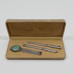 Conjunto de Presente com 2 Canetas, 1 Esferográfica e 1 Tinteiro E 1 Relógio Feminino, Marca Jinma, Não testado o funcionamento. Medidas da Caixa: Altura: 3 cm, Largura: 10 cm, Comprimento: 22 cm, Peso Total: 300 g.