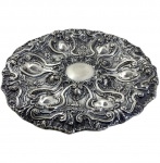 PRATA DE LEI - PRATO EM PRATA PORTUGUESA COM MARCA DE CONTRASTE EM FORMA DE ÁGUIA, INDICANDO TEOR 833 MILÉSIMOS , EXCELENTE EXEMPLAR DO  DO TRABALHO ROCAILLE EM PRATA PORTUGUESA, RICAMENTE ORNAMENTADA EM ALTO RELEVO COM DECORAÇÃO COMPOSTA POR VOLUTAS, CARTELAS ASSIMÉTRICAS, ELEMENTOS VEGETALISTAS E MOTIVOS FLORAIS DISPONDO DE RESERVA CENTRAL LISA, BORDA RECORTADA E MOVIMENTADA COM EXCELENTE TRABALHO DE CINZEL E REPUXO, DEMONSTRANDO QUALIDADE NA EXECUÇÃO. PESO: 584 GRS / MEDIDAS: 35,5 CM DE  DIÂMETRO.