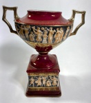PEQUENA ÂNFORA EM PORCELANA COM FIGURAS GREGAS, SEM TAMPA. MEDIDAS:
