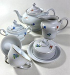 CONJUNTO DE BULE, AÇUCAREIRO, MATEGUEIRA, CREMEIRA E DUAS XICARAS DE CHÁ EM PORCELANA NACIONAL COM DECORAÇÃO FLORAL. MEDIDA DO BULE:  16 CM DE ALTURA a
