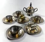 SEIS SUPORTES PARA COPO DE CAFÉ E AÇUCAREIRO (12,5 CM DE ALT.) EM METAL PRATEADO, DESGASTE NO METAL.
