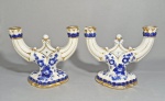 Par de antigos castiçais para duas velas em porcelana, decorado com flores em esmalte azul e detalhes dourados. Pintados a mão. Marca no fundo. Alguns desgastes no dourado. Med. 24 x 20 cm