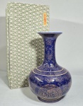 CHINA, SÉC.XIX/XX - Vaso em porcelana chinesa na cor azul cobalto, recoberto com farta decoração em dourado, com objetos sagrados budistas e símbolos auspiciosos. Selo vermelho honorífico Qianlong no fundo. Acompanha caixa original com etiqueta. Med. 32 cm de altura.