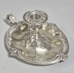 Antiga palmatória em metal branco com banho de prata, cinzelada, decorada com folhas de Acanto. Bordas chanfradas. Alguns desgastes. Contraste não identificado. Circa de 1900.  Med. 19 x 08 cm.