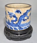 CHINA, DINASTIA QING, PERÍODO GUANGXU (1875-1908) - Porta pincéis (Bitong - Bush Pot)   em porcelana chinesa craquelada azul e branca, decorado com figuras de dragões de 4 garras e pérola flamejante entre nuvens e sobre ondas. Borda com esmaltação marrom. Marca honorífica Chenghua Nian Zao. Alt. 11 cm e diam. 12 cm.