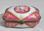 EUROPA, SÉC.XIX - Antiga caixa bombê em porcelana, decorada em vermelho bordo e azul, dourações e reserva central e interior com flores pintadas a mão. Guarnição em bronze. Marca azul não identificada no fundo. Med. 14 x 10 x 06 cm