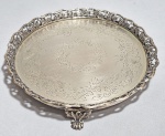 Antiga salva brasileira, Séc.XIX/XX em metal branco, fundo cinzelado com folhagens e galeria fenestrada, decorada com uvas e folhas de Parreiras. Pés em garra. Possui a marca "P". Med. 20 cm.