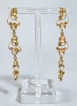Par de antigos e grandes brincos em metal dourado cinzelado com delicado trabalho filigranado e cravejado de pedras amarelas de tamanhos decrescentes. Med. 9 cm
