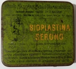 Lata Antiga de Bioplastina Serono  Edição Exportação (Anos 40)Rara lata litografada vintage do medicamento Bioplastina Serono, produzida pelo prestigiado Istituto Nazionale Medico Farmacologico, sediado em Roma, Itália. A peça apresenta um design gráfico clássico em tons de verde e amarelo, com o logotipo circular característico do laboratório e tipografia de época bem preservadaO interior da tampa preserva o encarte original em papel, com a instrução "Agita-se antes de usar" impressa em caligrafia cursiva azul. Um detalhe importante é a inscrição na base do papel: "Portogallo - Made in Italy", indicando que este lote específico foi produzido na Itália pela Serono para exportação ao mercado de língua portuguesa (Portugal ou Brasil).