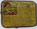 Lata Antiga "Vitamina Lorenzini"  Instituto Bioquímico Italiano (Milão, C. 1930/40)Belíssima lata litografada vintage da Vitamina Lorenzini, produzida pelo renomado Instituto Bioquímico Italiano sob o método do Prof. Dr. G. Lorenzini. A tampa é uma verdadeira peça de arte, apresentando uma ilustração bucólica detalhada de uma jovem camponesa colhendo cereais e frutas, simbolizando a origem vegetal das vitaminas (B1, B2, B3 e C) contidas no produto.