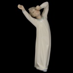 LLADRÓ 4870 - Designer: Fulgencio Garcia (1974  2000) - Boy Awaking (Menino Despertando). Estatueta espanhola em porcelana brilhante, Marca da manufatura no verso. 21 x 7 cm.