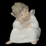 LLADRÓ 4539 - Designer: Fulgencio Garcia (1970) - Angel Thinking, (Anjinho Pensativo).). Estatueta espanhola em porcelana brilhante, Marca da manufatura no verso 10 x 9 cm.