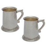 Coleção "King Harold" - Par de canecas com alças laterais, em metal inglês liso, espessurado a prata.  No fundo das peças selo da Collection Sheffield", sugere um estilo inspirado nos tradicionais trabalhos em da cidade de Sheffield, Inglaterra. O símbolo central é um leão desenfreado (rampant), um emblema heráldico comum que representa coragem e força. 12 x 23 cm. Peças Novas.