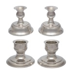 ST. JAMES - Conjunto de 4 castiçais baixos em metal espessurado a prata. Apresentam uma base campanular (em formato de sino), fuste em forma de balaústre e copos com anéis concêntricos. Design clássico e elegante, No fundo de um deles a marca da manufatura. 12 x 12 cm / 11 x 14 cm. Peças novas