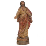 Séc. XIX - Sagrado Coração de Jesus Belíssima Imagem em madeira esculpida, policromada e dourada. Apresenta-se com ricas vestes, pregueadas e bordadas, o peito à mostra com o coração pulsando, e a mão direita apontando os necessitados. Base chanfrada. 60 x 27 x 12 cm. Pequenas marcas do tempo. Acervo Fazenda Pao- Grande, Ex Coleção Plácido Gutierrez