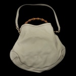GUCCI  Bolsa modelo Bamboo Peggy em couro marfim com alça de mão estruturada em bambu natural.  Aça de ombro longa em couro, para uso transversal ou tiracolo. Em formato conhecido como hobo, é maleável e oferece muito espaço interno para o dia a dia. 69 x 44 x 13 cm. Peça usada, em bom estado de conservação.