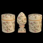 Terno em cerâmica chinesa, de estilo tradicional, constando de 2 potes cilíndricos e 1 pinha. Apresenta decoração com  estampas florais e detalhes dourados em estilo orientalista. 20 x 16 cm / 19,5 x 16 cm (potes). 25 x 12 x 12 cm (pinha).