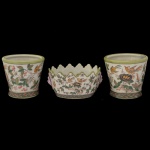 Terno em porcelana chinesa, decoradas em policromia com pássaros, voando ou pousados em árvores. Constando de um par de cachepôs cônicos e um bowl circular com pegas laterais e borda dentada. Marcas sob as bases. 13 x 14 cm (cachepô). 9 x 18 x 14 cm (floreiro).